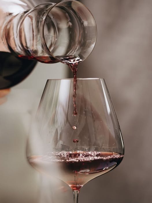 Red wine being poured into a glass at AURA by Bianco