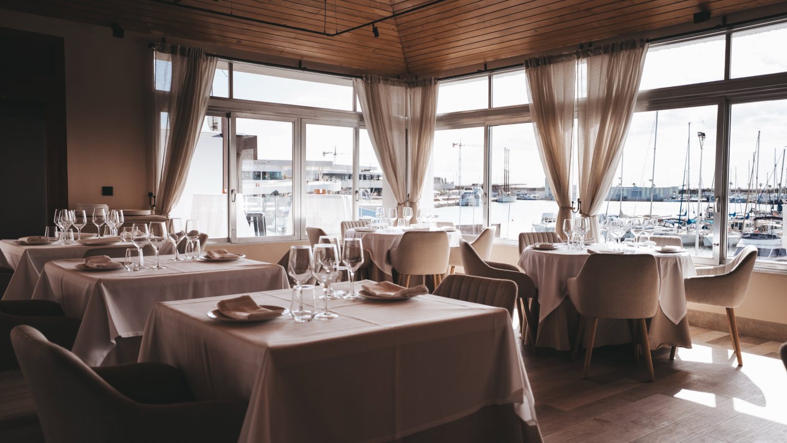 AURA by Bianco dining room with windows overlooking Torrevieja marina